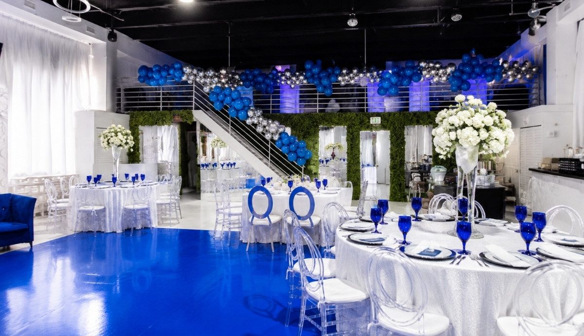 Royal blue corporate gala with a grand staircase and white floral tables